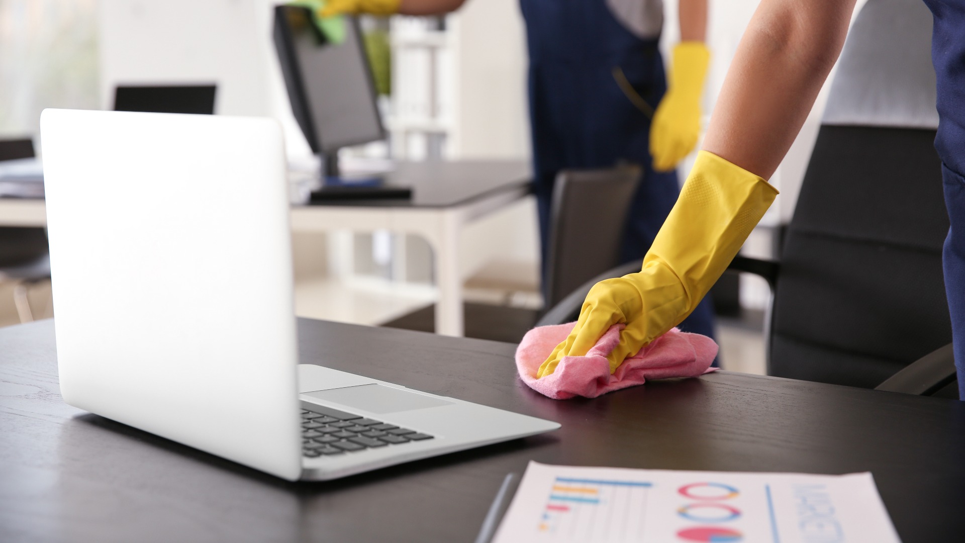 Hausmeister wischt Tisch im Büro ab